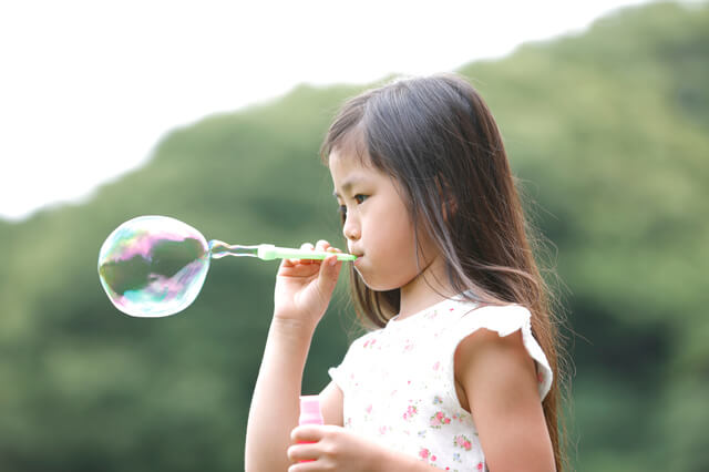 普通の吹き具でシャボン玉を吹く子供