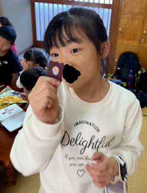 穴の空いたお菓子を見つめる笑顔の子供