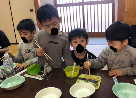 ご飯を食べる子供と変顔をする子供